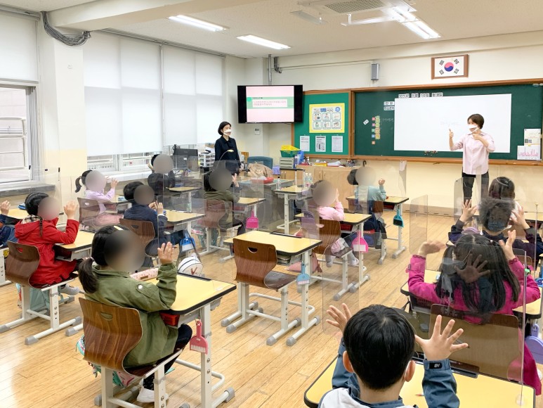 따뜻한동행_장애이해교육_수업모습(박수를 의미하는 수어를 배우는 학생들)